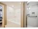 A well-lit bathroom featuring a jet tub, recessed lighting, and glass-enclosed shower at 4501 S Ocean Blvd., North Myrtle Beach, SC 29582