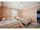 Cozy bedroom featuring two twin beds, wood-look floors, peach-colored walls and ceiling fan at 4501 S Ocean Blvd., North Myrtle Beach, SC 29582