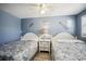 Bedroom featuring two twin beds, wood-look floors, blue-colored walls and ceiling fan at 4501 S Ocean Blvd., North Myrtle Beach, SC 29582