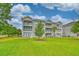 Exterior view of a multi-story condo building with balconies and landscaped grounds at 4683 Wild Iris Dr. # 104, Myrtle Beach, SC 29577