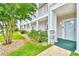 Inviting exterior with landscaped garden and a view of the building's façade and porch at 4683 Wild Iris Dr. # 104, Myrtle Beach, SC 29577