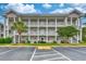 Exterior view of a multi-story building with a parking lot and landscaping at 4683 Wild Iris Dr. # 104, Myrtle Beach, SC 29577