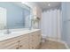 Bright bathroom featuring a double sink vanity, framed mirror, and a shower with white curtain at 4812 Magnolia Lake Dr. # 102, Myrtle Beach, SC 29577