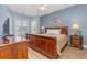 Primary bedroom featuring a wooden bed frame, ceiling fan, and bright lighting at 4812 Magnolia Lake Dr. # 102, Myrtle Beach, SC 29577