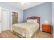 Bright bedroom with wood floors, a bed with white bedding and a view to an ensuite bathroom at 4812 Magnolia Lake Dr. # 102, Myrtle Beach, SC 29577