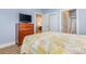 Bedroom featuring a wooden dresser with TV, wood floors and view into bathroom and hallway at 4812 Magnolia Lake Dr. # 102, Myrtle Beach, SC 29577