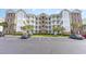 Exterior of condo building showing parking lot and well-maintained landscaping at 4812 Magnolia Lake Dr. # 102, Myrtle Beach, SC 29577