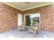 Covered patio with brick and seating, a sliding glass door, and a view of the complex at 4812 Magnolia Lake Dr. # 102, Myrtle Beach, SC 29577