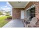 Covered patio with tan plastic chairs, brick siding, and view of lawn at 4812 Magnolia Lake Dr. # 102, Myrtle Beach, SC 29577