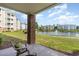 View from patio overlooking a pond, lush grass, a fountain, and neighboring condo buildings at 4812 Magnolia Lake Dr. # 102, Myrtle Beach, SC 29577