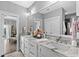 Bright bathroom featuring double sinks with marble counters and white cabinetry at 4832 Williams Island Dr., Little River, SC 29566