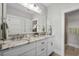 Bright bathroom featuring double sinks with marble counters and white cabinetry at 4832 Williams Island Dr., Little River, SC 29566