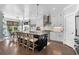 Elegant kitchen featuring a spacious island, white cabinetry, stainless steel appliances, and modern pendant lighting at 4832 Williams Island Dr., Little River, SC 29566
