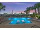 Relaxing pool area with comfortable loungers offering serene views of the waterway and colorful sunset at 4832 Williams Island Dr., Little River, SC 29566