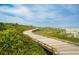 Picturesque boardwalk surrounded by lush greenery leading to the ocean and sandy beach at 4879 Dahlia Ct. # 302, Myrtle Beach, SC 29577