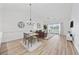 Open dining area with chandelier, hardwood floors, and a view into the comfortable living room with a private balcony at 4879 Dahlia Ct. # 302, Myrtle Beach, SC 29577