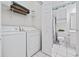 Efficient laundry room with washer, dryer, shelving, and adjacent bathroom for convenience at 4879 Dahlia Ct. # 302, Myrtle Beach, SC 29577