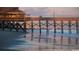 Picturesque view of a pier at sunset with calm waves and distant city skyline at 4879 Dahlia Ct. # 302, Myrtle Beach, SC 29577