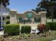 Community entrance sign amid manicured landscaping and vibrant flowers at 4879 Dahlia Ct. # 302, Myrtle Beach, SC 29577