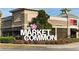 Exterior of The Market Common with Real Living office sign and landscaping at 4879 Dahlia Ct. # 302, Myrtle Beach, SC 29577