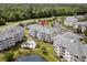 Stunning aerial view of condo buildings, pool, and a serene pond nestled among lush greenery and mature trees at 4895 Luster Leaf Circle # 304, Myrtle Beach, SC 29577