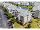 Low aerial of the complex highlighting brick accents, landscaping, parking, and proximity to pond in a park-like setting at 4895 Luster Leaf Circle # 304, Myrtle Beach, SC 29577