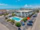 Aerial view showcases the building near a swimming pool, parking, and lush landscaping at 5001 N Ocean Blvd. # 1F, North Myrtle Beach, SC 29582