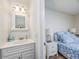 The vanity and mirror of an ensuite bathroom featuring a bedroom on the other side of a doorway at 5001 N Ocean Blvd. # 1F, North Myrtle Beach, SC 29582