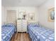 Bright bedroom displaying two twin beds, matching decor, and wood-look flooring at 5001 N Ocean Blvd. # 1F, North Myrtle Beach, SC 29582