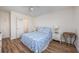 Comfortable bedroom features wood floors, white furnishings, and a coastal-themed bedspread at 5001 N Ocean Blvd. # 1F, North Myrtle Beach, SC 29582