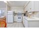 Well-lit kitchen with a refrigerator, microwave, dishwasher, and white cabinetry for efficient living at 5001 N Ocean Blvd. # 1F, North Myrtle Beach, SC 29582