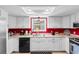 Bright kitchen with white cabinets, black appliances, and red accent wall at 507-C 2Nd Ave. N, North Myrtle Beach, SC 29582