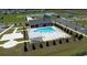 Aerial view of a sparkling community pool with lounge chairs, shaded pergola, and lush landscaping at 564 Strawberry Field Way, Galivants Ferry, SC 29544