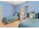 Charming bedroom with two twin beds, blue walls, and a window letting in natural light at 5840 Longwood Dr. # 303, Murrells Inlet, SC 29576