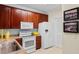 Well-lit kitchen with wooden cabinets, white appliances, and neutral countertops offers practical cooking space at 5840 Longwood Dr. # 303, Murrells Inlet, SC 29576