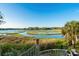 Backyard water view from a patio with lush greenery and seating at 600 48Th Ave. S # 201, North Myrtle Beach, SC 29582
