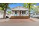 Charming cottage with a covered porch and red brick parking pad, perfect for relaxing outdoors at 6001 South Kings Hwy., Myrtle Beach, SC 29575