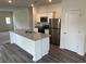 Modern kitchen with stainless steel appliances, a spacious island, and stylish gray wood floors at 630 Muster Field Ct., Conway, SC 29526
