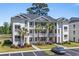 Three-story condo building featuring private balconies, lush landscaping, and convenient parking at 650 River Oaks Dr. # 46I, Myrtle Beach, SC 29579