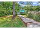 View of a cozy two-story home with a brick and blue exterior, surrounded by mature trees at 715 9Th Ave. S, Surfside Beach, SC 29575