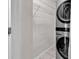Convenient laundry room features shelving and a modern stacked washer and dryer unit at 715 9Th Ave. S, Surfside Beach, SC 29575