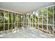 Spacious screened porch with tile flooring and a view of trees and a wood fence at 816 Kittiwake Ln., Murrells Inlet, SC 29576