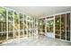 A bright, airy screened porch with tile flooring and views of the surrounding greenery at 816 Kittiwake Ln., Murrells Inlet, SC 29576