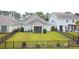Aerial view of the backyard with a lush lawn, fenced perimeter, and screened porch at 932 Mildred Ct., Murrells Inlet, SC 29576