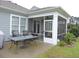 Outdoor screened in porch with a table and chairs to enjoy the lovely backyard at 932 Mildred Ct., Murrells Inlet, SC 29576