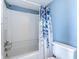 Bright bathroom featuring a shower/tub combination and a blue leafy shower curtain at 9400 Shore Dr. # 523, Myrtle Beach, SC 29572