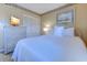 Comfortable bedroom features a television, closet, white bedspread, and wicker bedside table at 9400 Shore Dr. # 523, Myrtle Beach, SC 29572