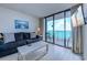 Living room with modern decor, comfy couch, and sliding glass doors to the patio with ocean views at 9400 Shore Dr. # 523, Myrtle Beach, SC 29572