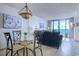 Bright living room with ocean view from the sliding door and charming Tiffany-style light fixture at 9400 Shore Dr. # 523, Myrtle Beach, SC 29572