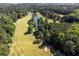 Lush golf course aerial showcasing mature trees, a tranquil pond, and manicured greens at 9569 Indigo Club Dr., Murrells Inlet, SC 29576